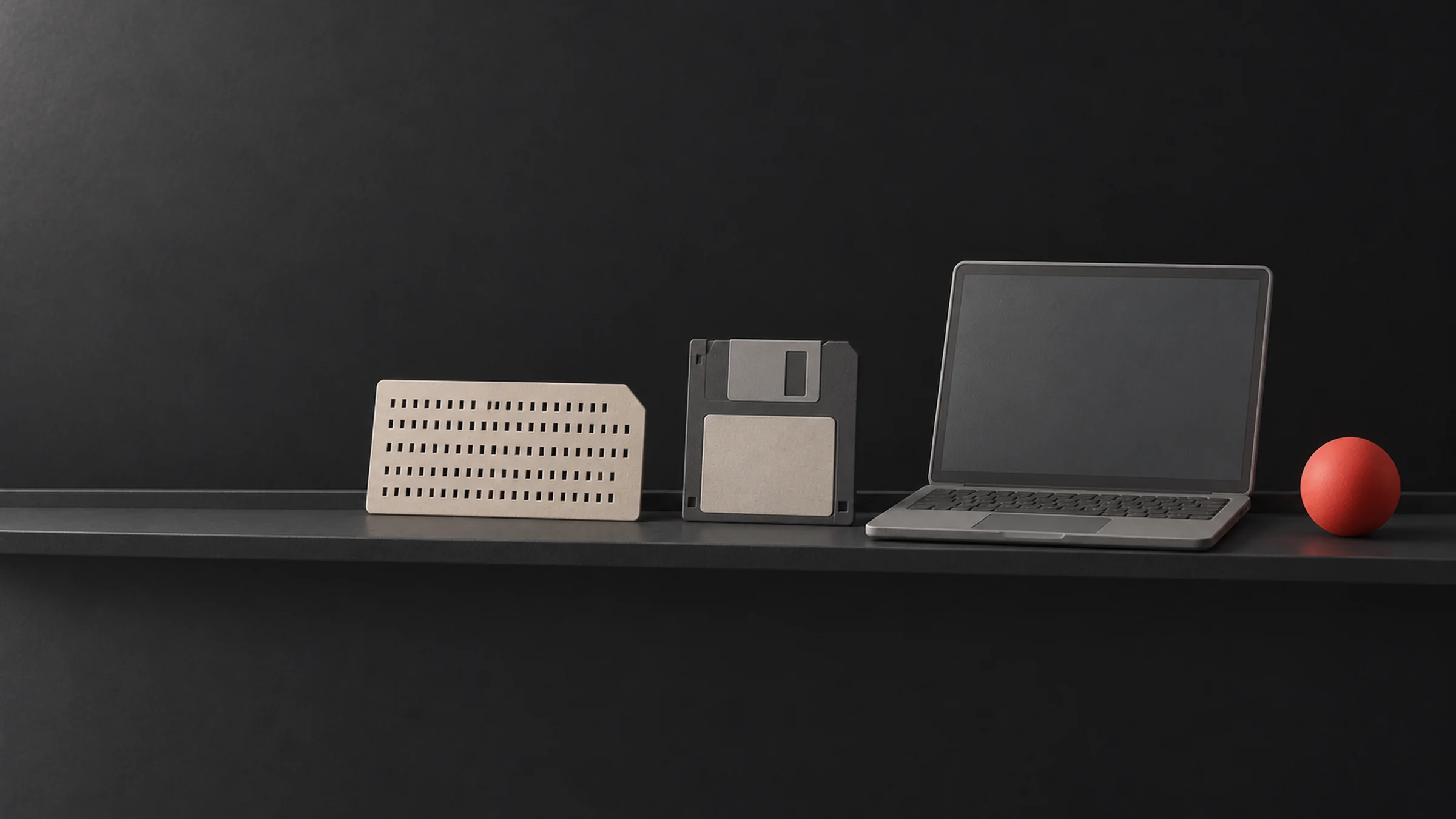 A shelf with a punched card, a floppy disk and a laptop, ending with a small red sphere